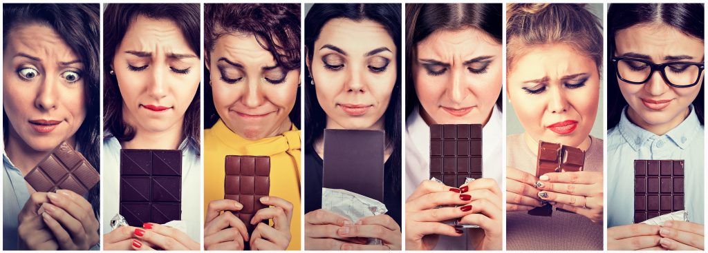 Diätfrust vermeiden: mehrere Frauen sind mit einer Tafel Schokolade zu sehen und schauen unglücklich